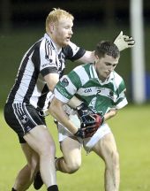 David Collins shielding the ball from his St. Saviour's opponent during the County Senior Football Championship Quarter Final played at Fraher Field